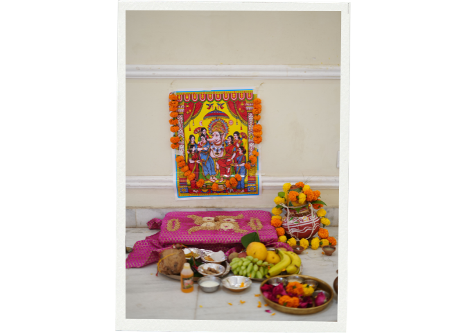 A colorful Ganesh puja altar with traditional offerings and marigold decorations.