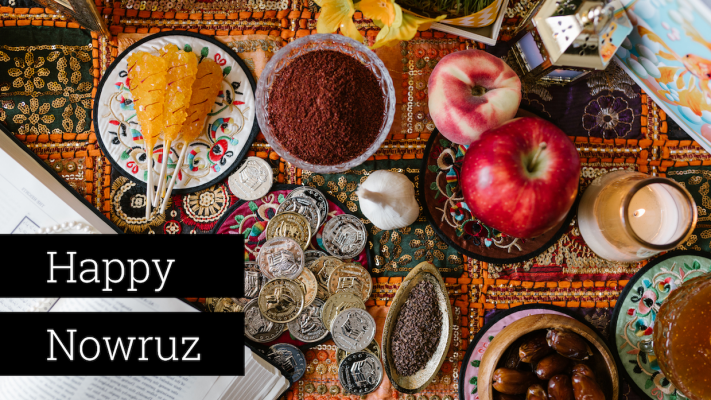A table covered in fruits, coins, and traditional foods for Nowruz.