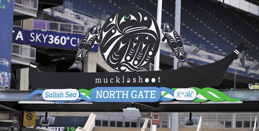 The north gate to Lumen Field, adorned with Native art and a sign that says 