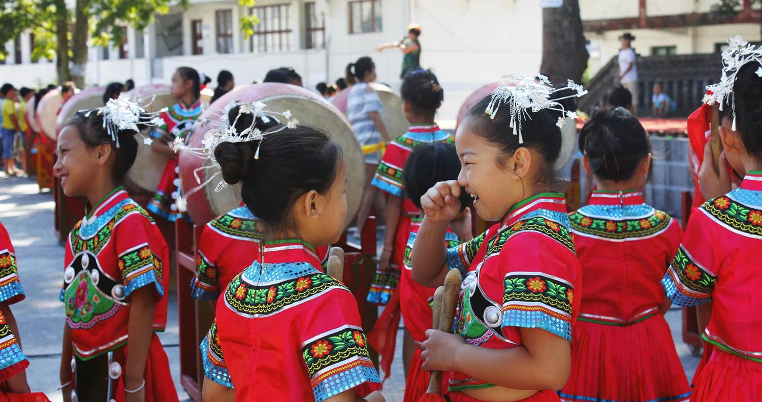 A group of young girls in festive clothes laughing and in conversation.