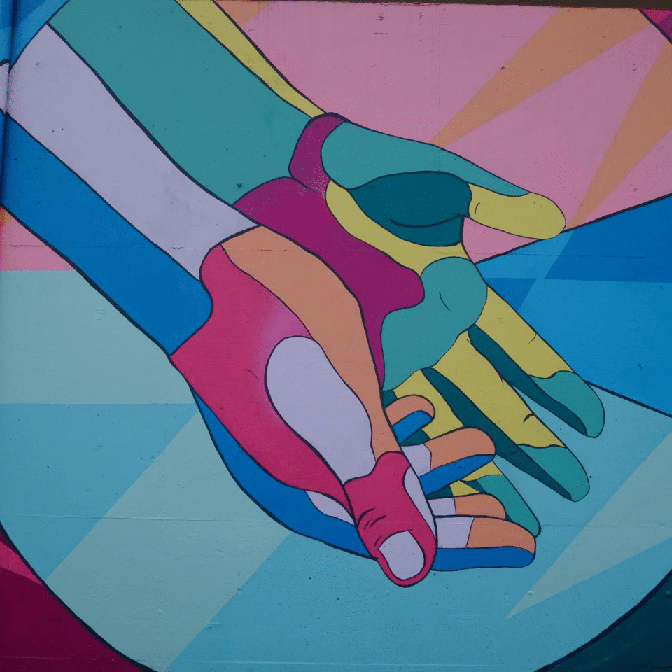 A mural depicting a pair of hands in positions of presenting, receiving, and embracing.